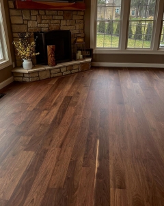 hardwood floor in front of a fireplace and large windows